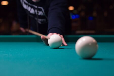Russian billiards game in progress: player aims to shoot balls with cueの写真素材