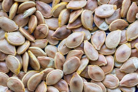 Close-up food background of dry fried yellow white pumkin seeds nutsの写真素材