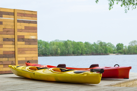 Two kayak boats on wooden deck at kayak station near river bankの写真素材