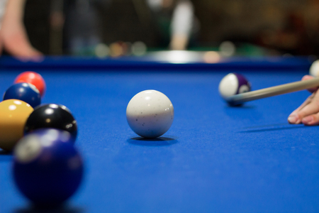 Billiard pool game in progress, player aims to shoot balls with cueの写真素材