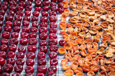 Background pattern of fresh mellow cherry and apricot berries prepared for cooking and sun drying...