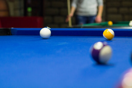 Billiard pool game in progress, balls are on blue table clothの写真素材