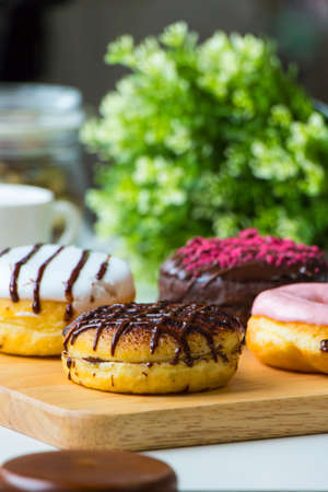 Donuts on wooden plates and decorations,Donuts,Donuts are placed on a wooden plate with green leaves...