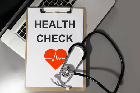 medical stethoscope on notebook and writing paper on gray desk,Medicine and Research,health checkの写真素材