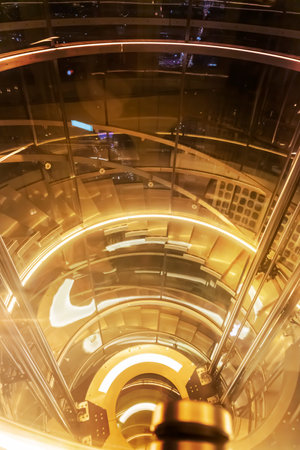 Steel structure spiral staircase at night with warm lightsの写真素材