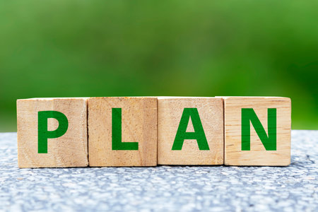 plan on wooden box on green background,Doing business must have a plan to work towards the goal.の写真素材