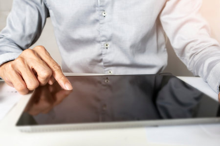 Businessman touching tablet screen checking work and conducting business according to plan