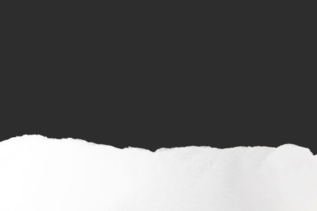 White paper crumples and torn edges of paper with a black background for graphic design and text insertion.の写真素材