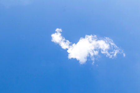 Clear sky and a single white cloud in a clear sky, Floating of a single cloud in the sky, Lonely perspective of a lonely journey of a cloudの写真素材