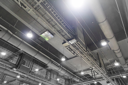 Dark grey air conditioning system and lighting system in large interior spaces. Interior decoration...