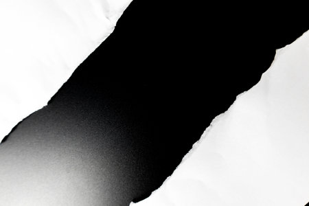 White paper crumples and torn edges of paper with a black background for graphic design and text insertion.の写真素材