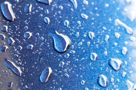 Water drops on blue powder coated surface, focus view.の写真素材