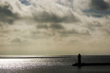 A sunny day at the beach, with clouds hiding parts of the sun.