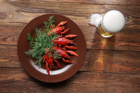 boiled crawfish on wooden surface with a beer and dill. old style plateの写真素材