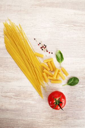 pasta with tomato and shpinat on white wood background, ingredients for making lasagna and other pastaの写真素材