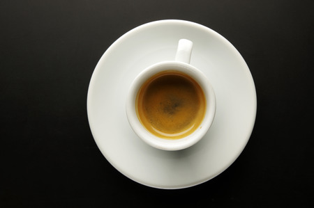 A cup of fragrant coffee on a black background, top viewの写真素材
