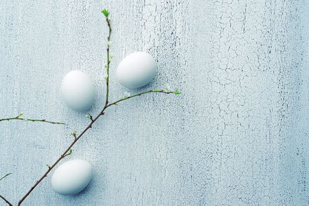 White natural eggs and fresh spring branches on a white vintage background. Template for postcard,...