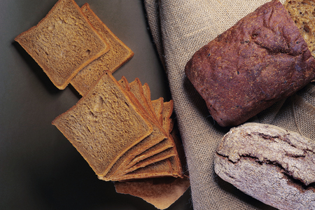 The village grain bread is cut, lying on a rough sacking