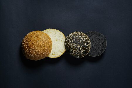 top view of two black and white burger rolls on a black backgroundの写真素材