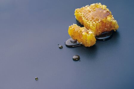 honey bee flows out of honeycomb on a black backgroundの写真素材