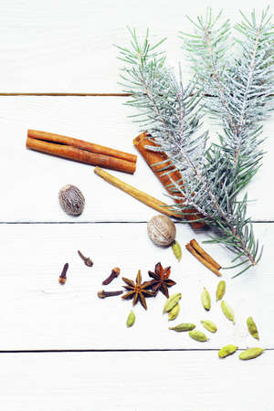 top view snow-covered spruce branches and spices on a white wooden board. Mock up for greeting cards, invitation cards.の写真素材
