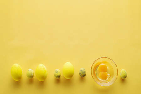 Layout of Easter eggs on a pastel yellow background. Minimal concept. Flat lay. Punchy pastels. Top...