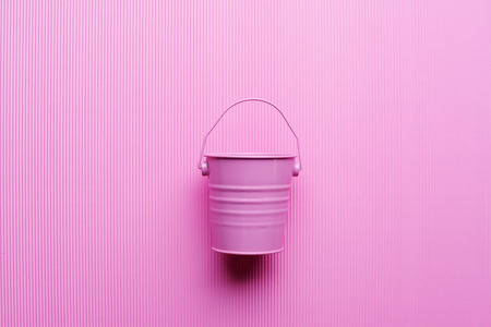 A cute pink bucket for candy or flowers on a pink background. Top view. Punchy pastels. Copy space.の写真素材