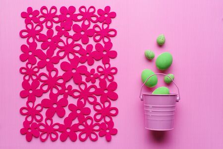 Easter eggs in a decorative pink bucket on a pink background. Top view. Space for text. Punchy...