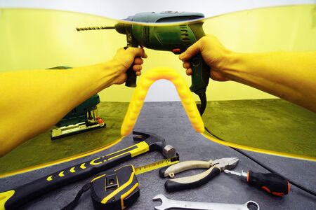 A view of the hands with tools through the yellow protective glasses. First person view.