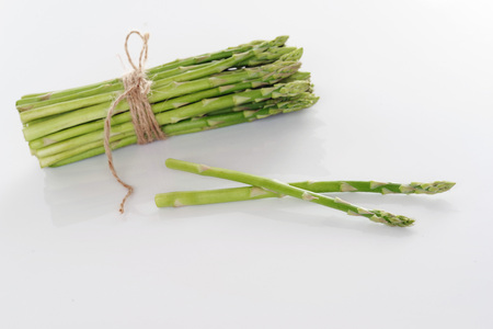 A bunch of young asparagus on a white background.の写真素材