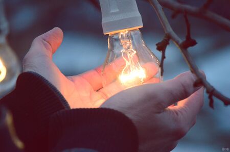 Hands heat from a light bulbの写真素材