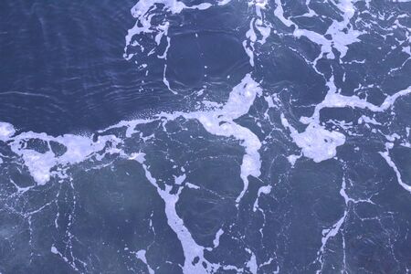 Blue water foam with white wavesの写真素材