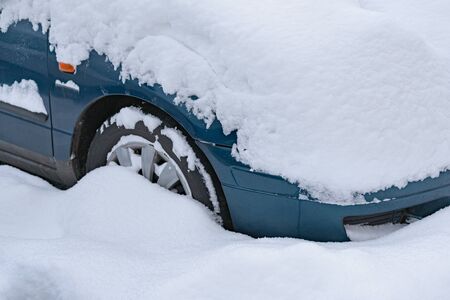 Close up on car standing in the parking lot covered with a thick layer of snow.の写真素材