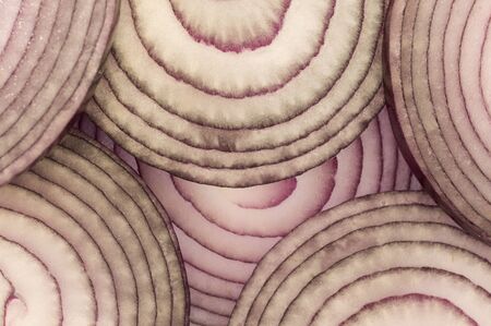 close up of red onion slices stacked over each otherの写真素材