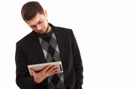 Casual businessman joyfully  looking  at his tablet screen  isolated on white
