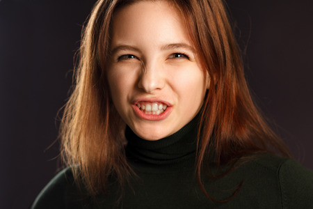 Closeup portrait of young woman showing her teeth and hissingの写真素材