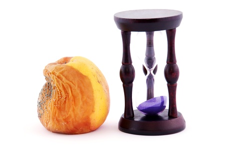 Rotten apple with a mold and an hourglass isolated on white background