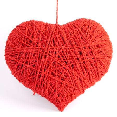 Red heart shape symbol made from wool isolated on white background の写真素材