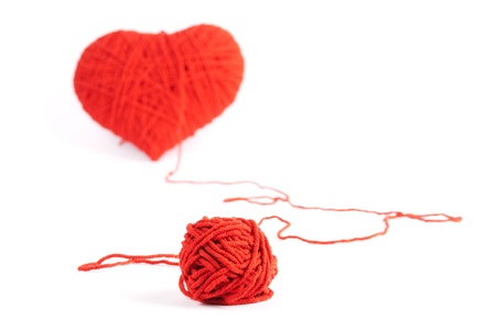 Red heart shape symbol made from wool isolated on white background の写真素材