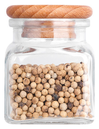 White pepper in a glass bottle. Isolated on white backgroundの写真素材