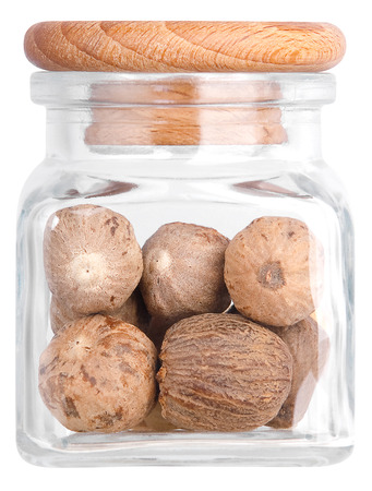 Nutmeg in a glass bottle. Isolated on white backgroundの写真素材