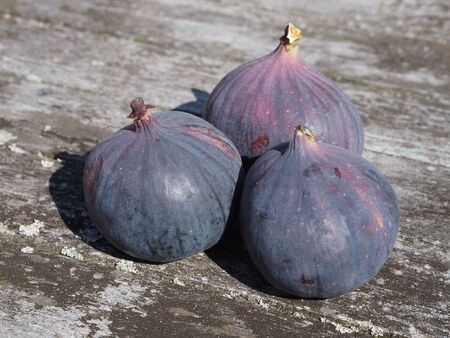 Some fresh figs on a wooden deskの写真素材