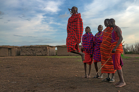 MAASAI VILLAGE, KENYA - JANUARY 2 2015: Tourists visit maasai village near Maasai Mara. Watching traditions of local tribes is one of the most popular attraction for tourists who come to Kenya.のeditorial素材