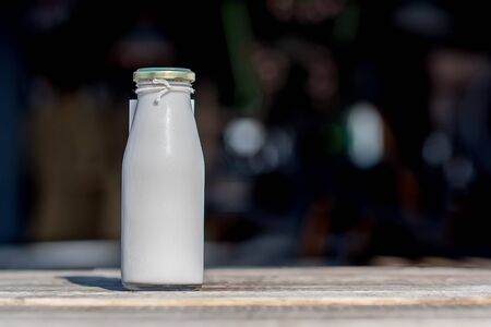 Milk in glass bottle in rustic backgroundの写真素材