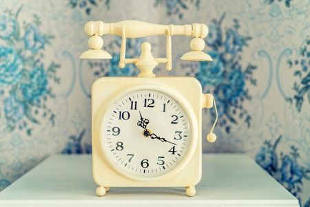 Vintage white alarm clock styled as retro telephone