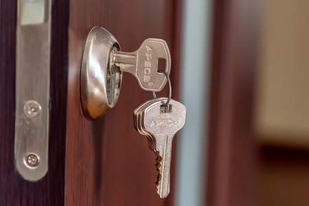 Close-up photography of key in keyhole of modern doorの写真素材