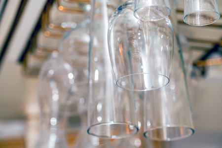 Luxury wine and champagne glasses hanging up side down in the pubの写真素材