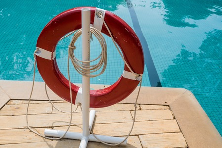 Red lifebuoy near swimming pool at tropical hotelの写真素材