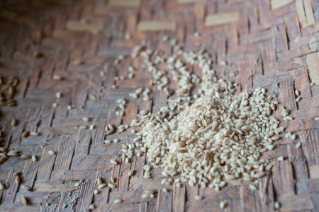 Grains of raw white rice in a bowl on rustic backgroundの写真素材