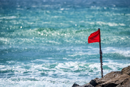 Red warning flag on beach showing that swimming is dangerous or prohibitedの写真素材